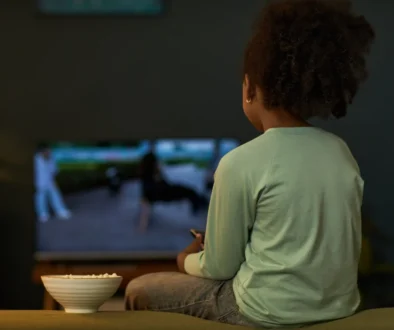 Dítě sedí před televizí.