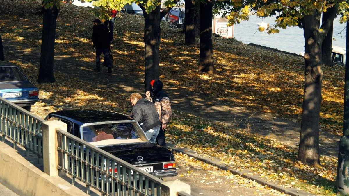 Retro auta parkují podél plotu.