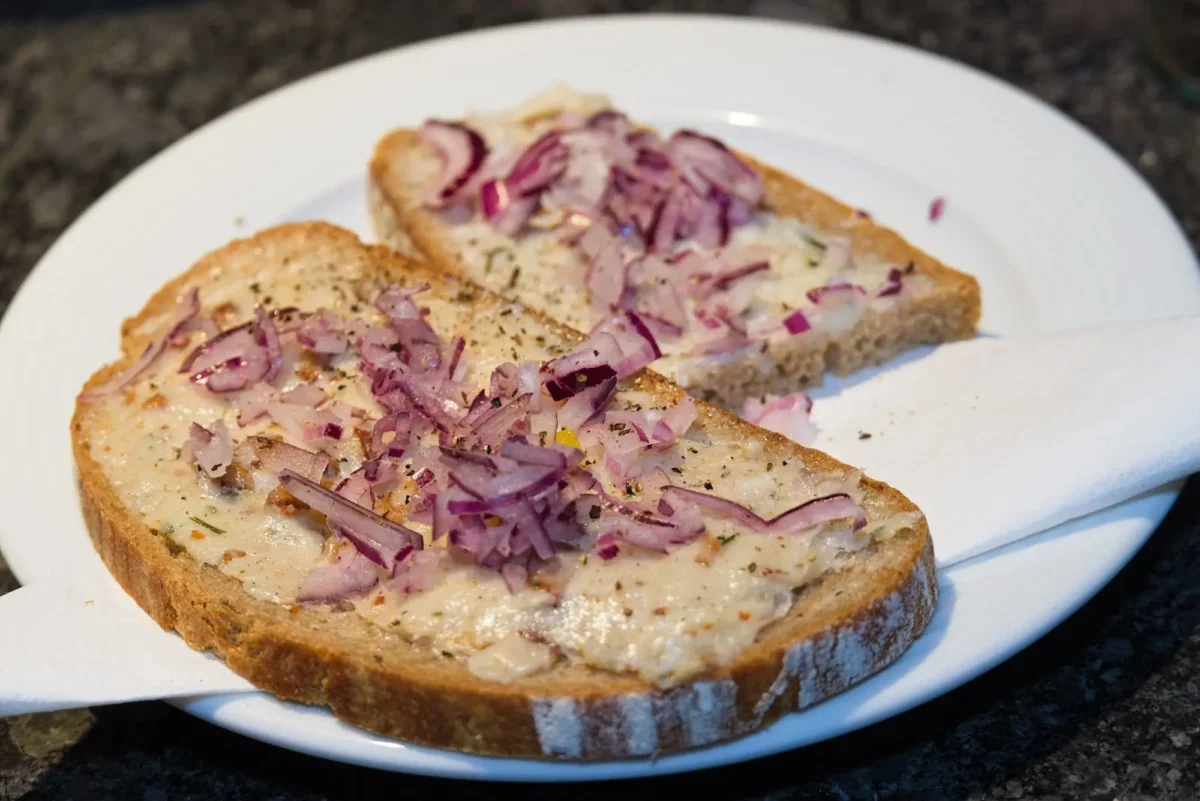 Na talíři leží chleba se sádlem.