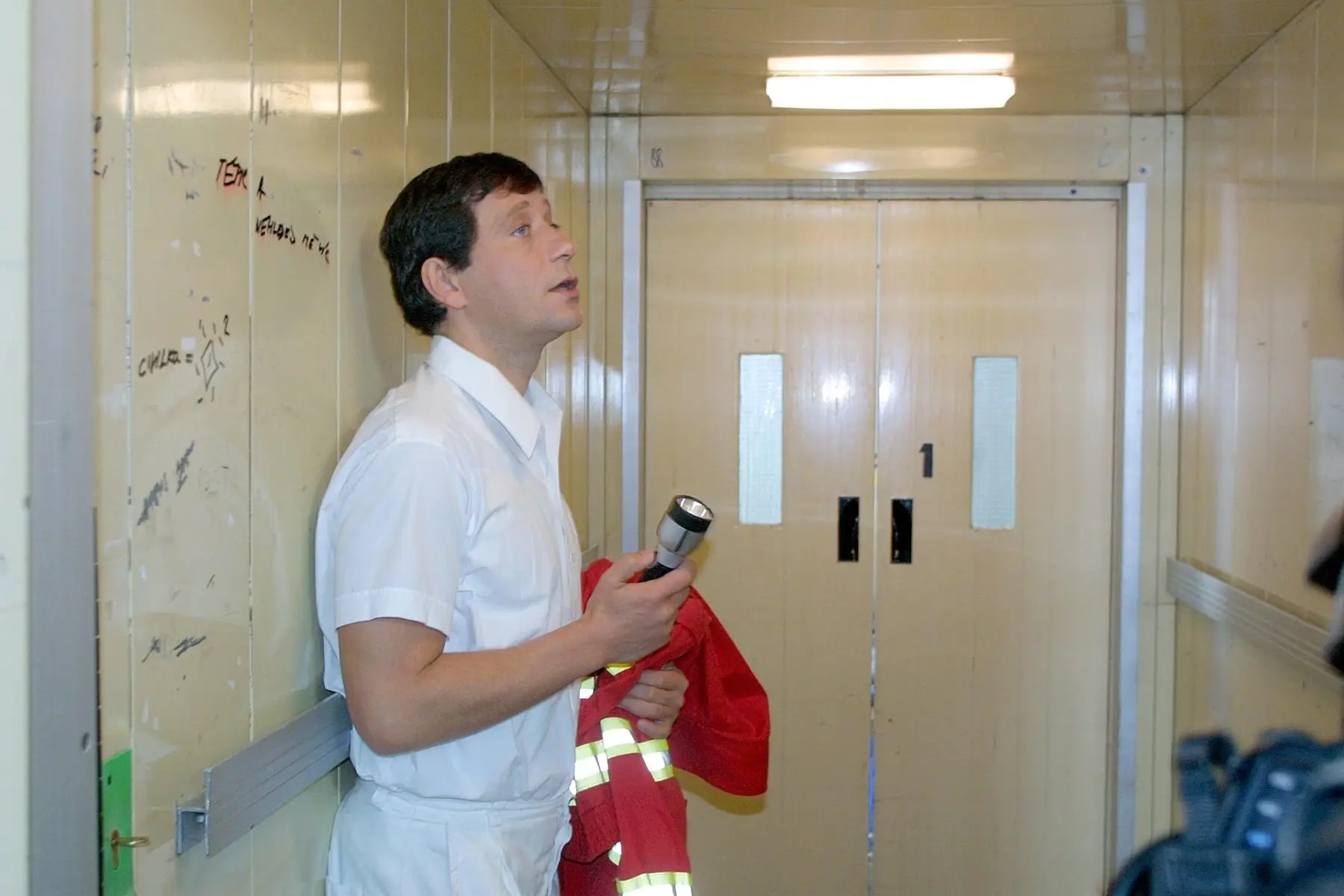 Pavel Kříž stojí s baterkou v ruce.