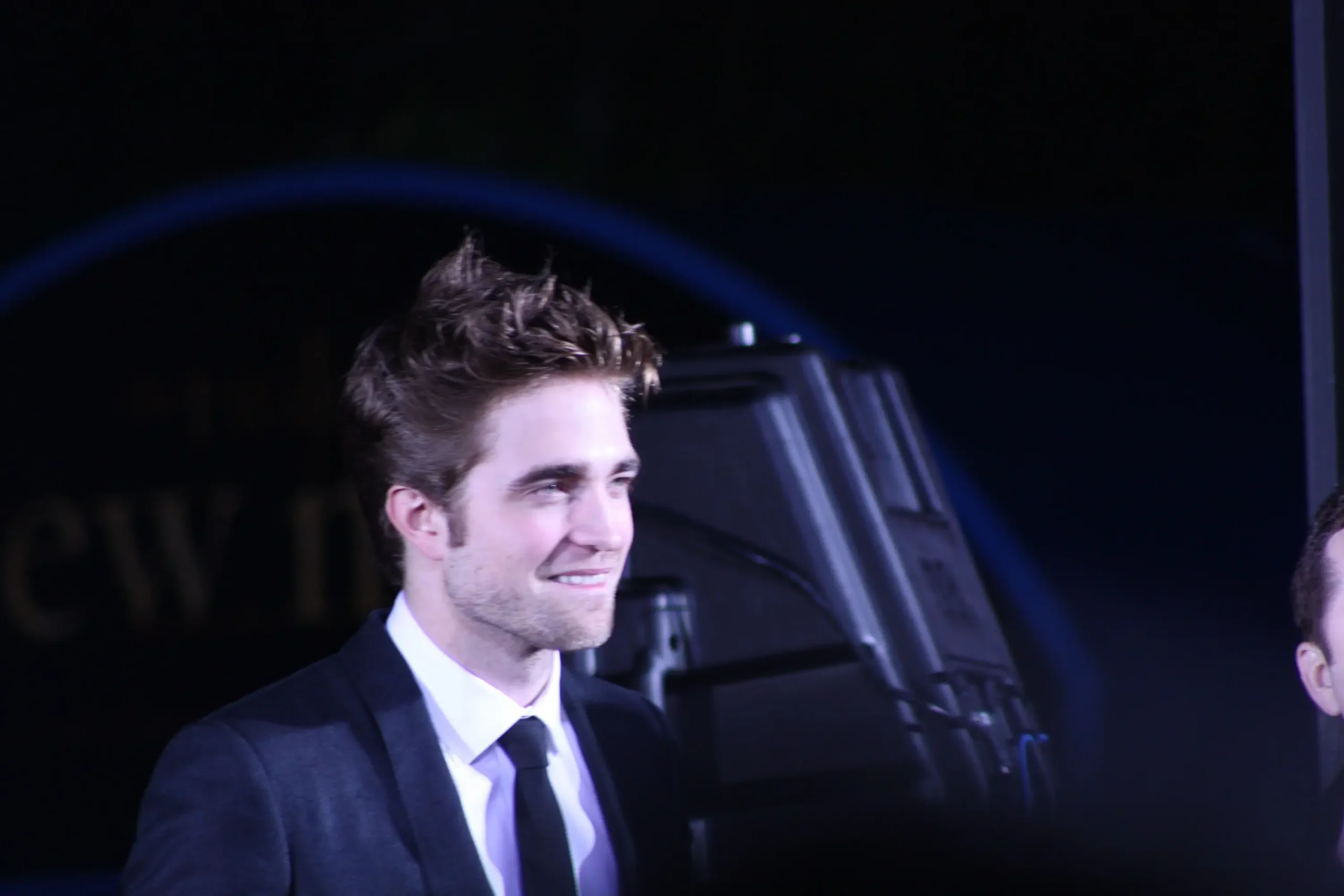 Robert Pattinson se usmívá.