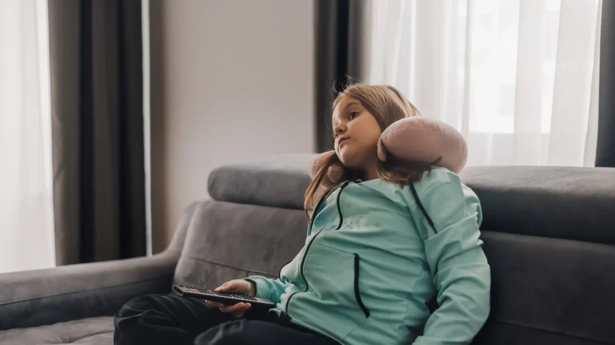 Dívka přepínající televizi.