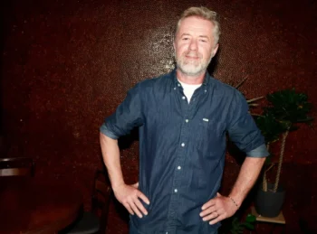 Jiří Langmajer stojí s rukama v bok.