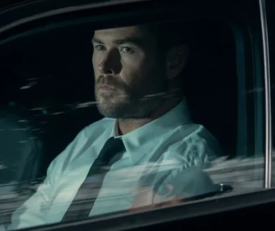 Chris Hemsworth sedí v autě.