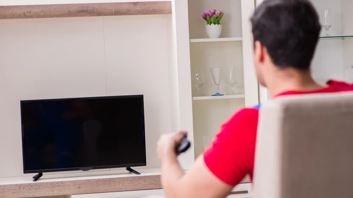 muž zapíná televizi