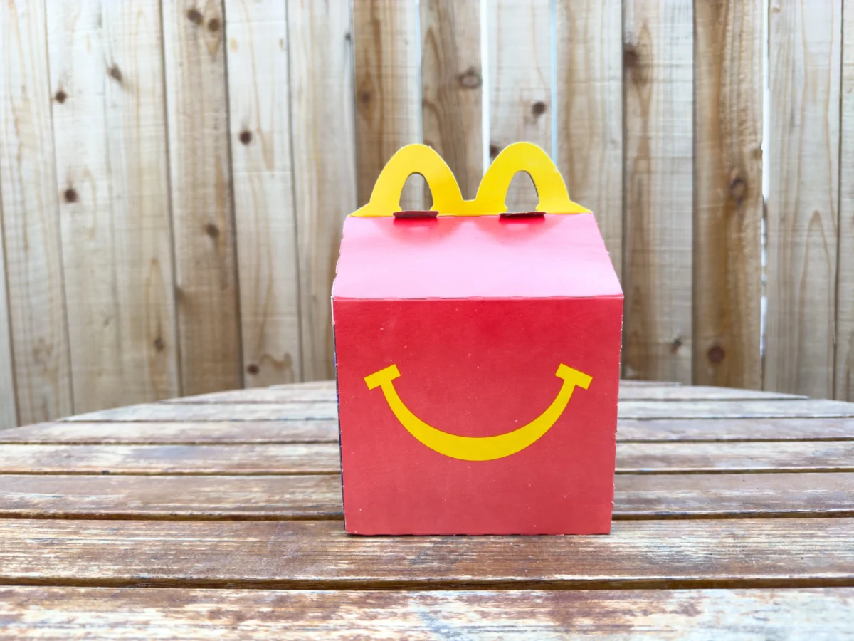 Na stole leží krabička Happy Mealu.