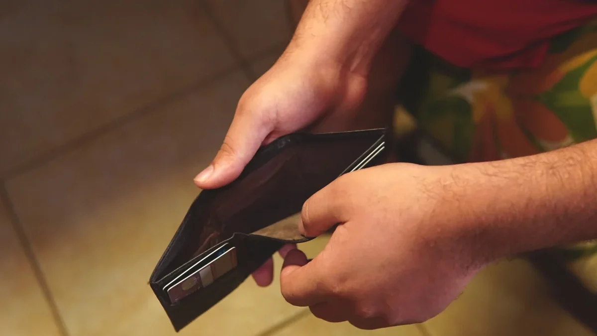 Člověk otevírá prázdnou peněženku.