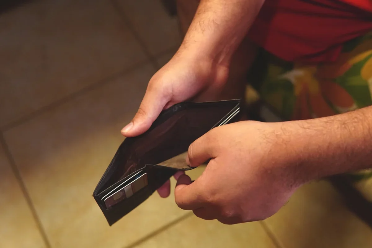 Člověk otevírá prázdnou peněženku.