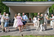 Senioři venku tančí.