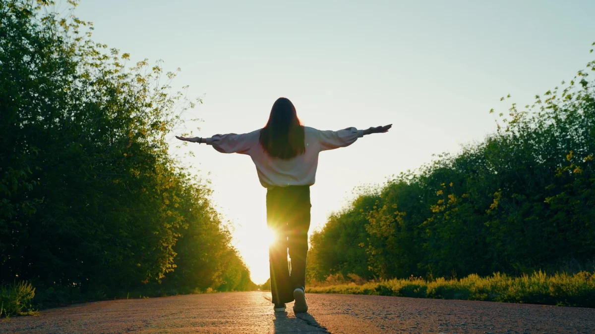 Žena má rozpažené ruce.