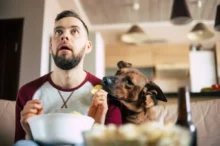 Vyděšený muž kouká na televizi se psem
