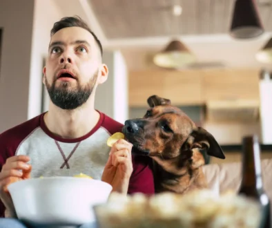 Vyděšený muž kouká na televizi se psem