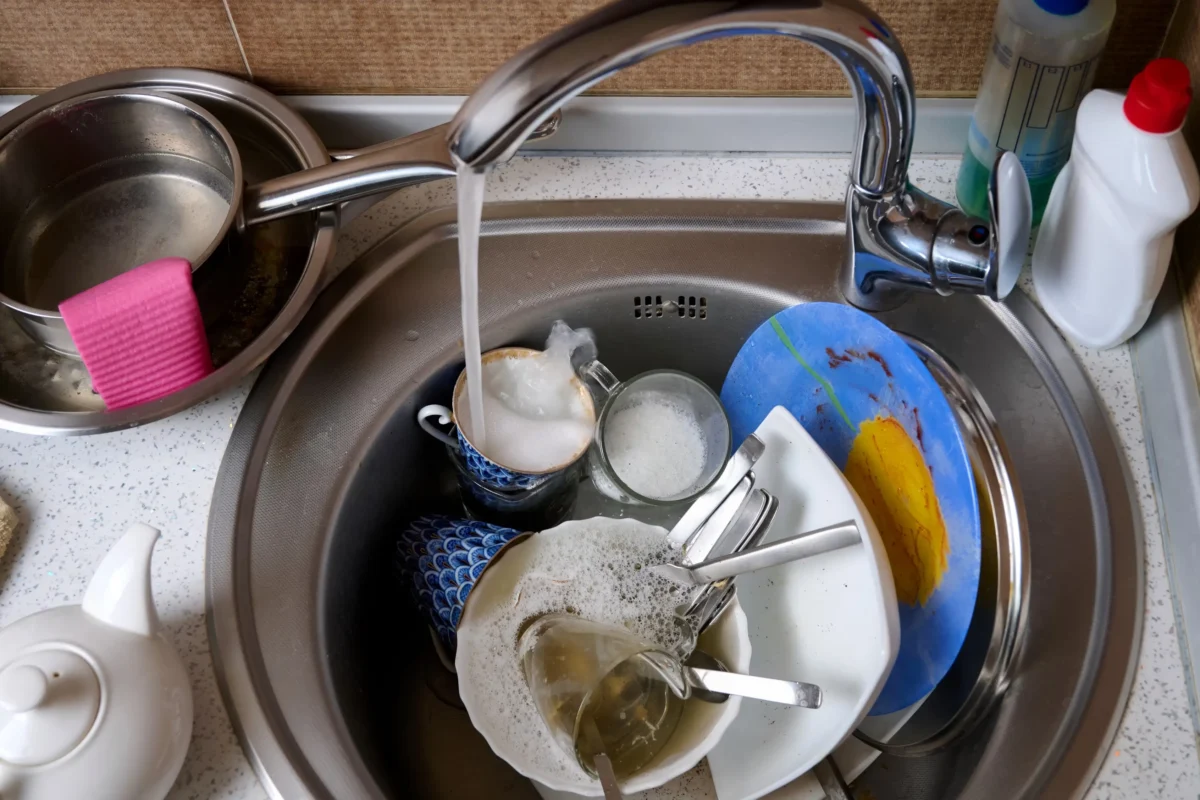 V dřezu se hromadí nádobí.
