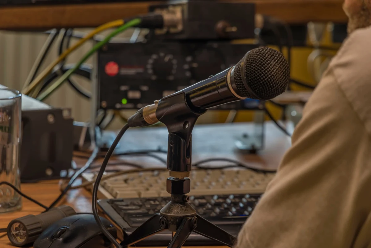 Muž sedí za mikrofonem. 