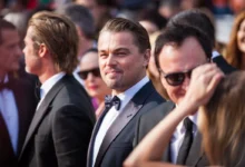 Leonardo DiCaprio stojí mezi lidmi.