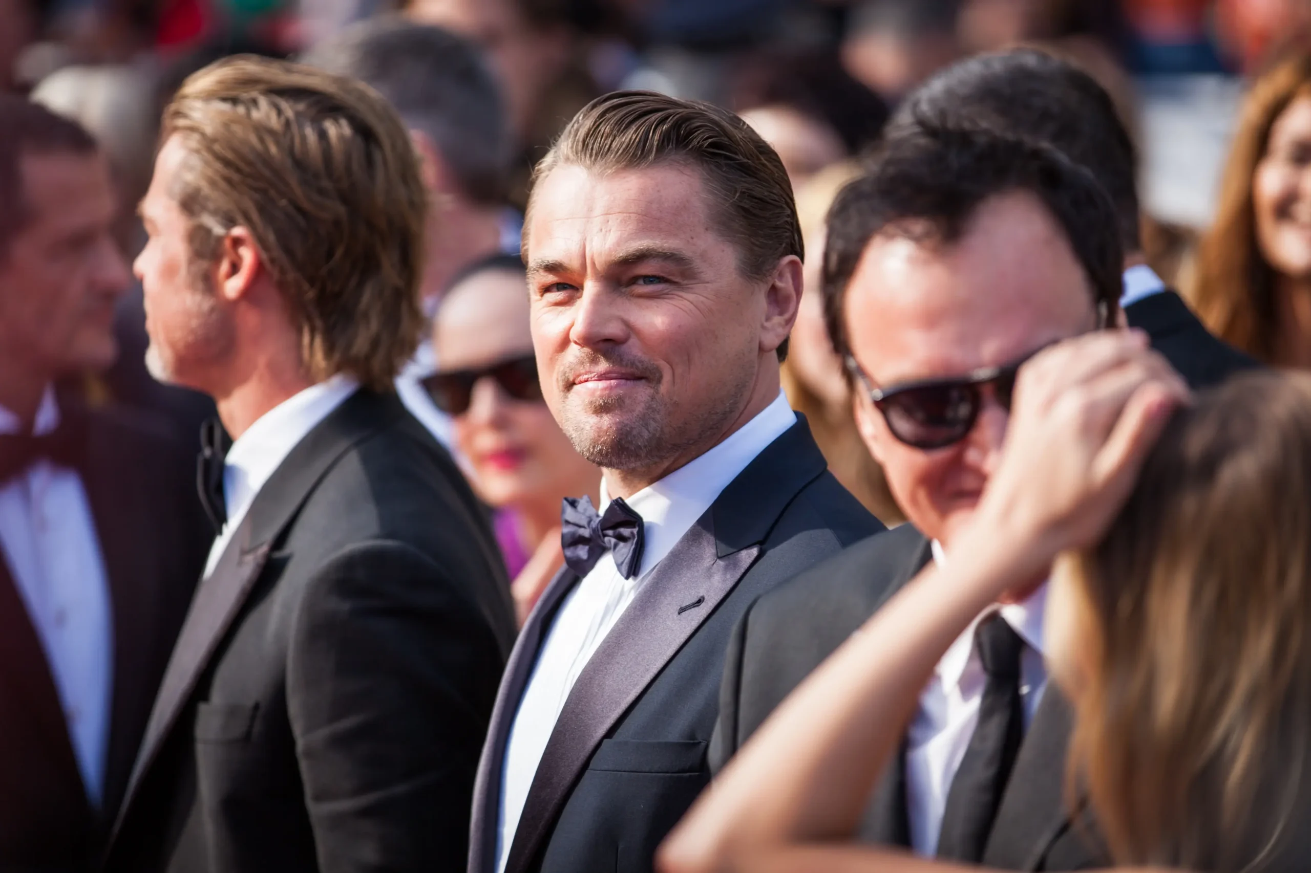 Leonardo DiCaprio stojí mezi lidmi.
