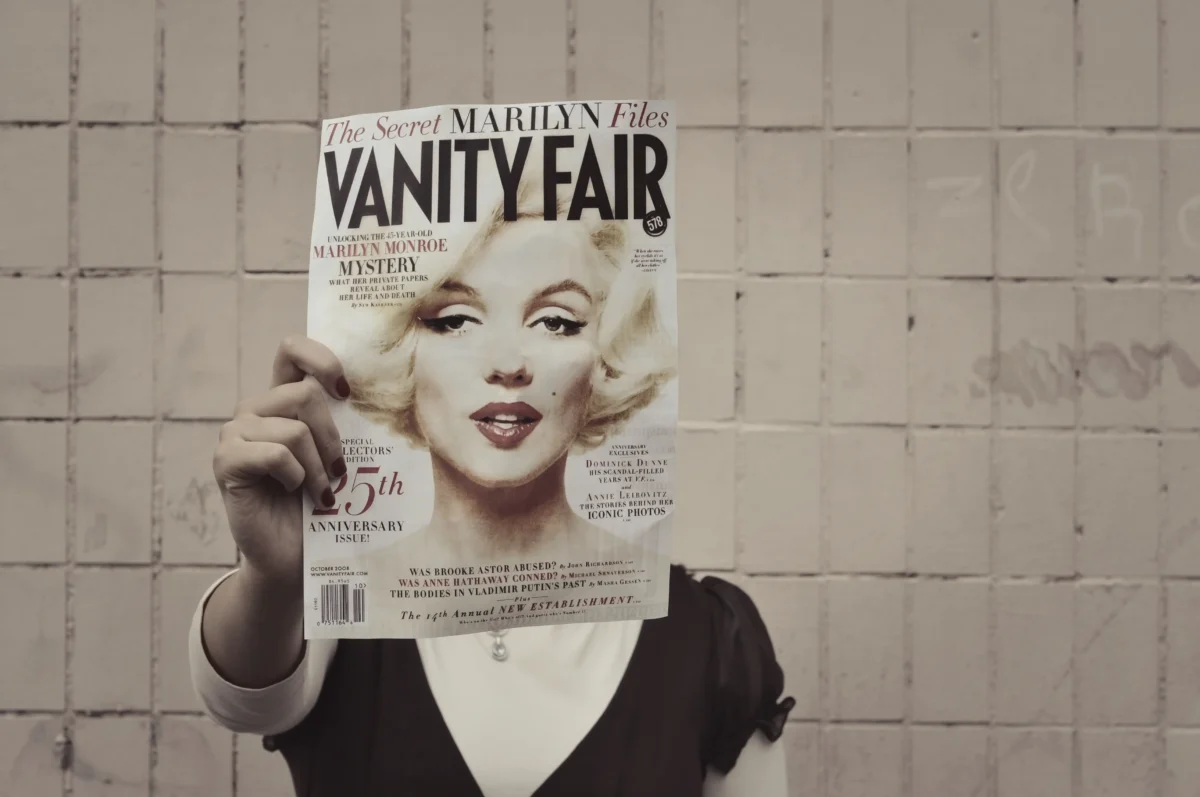 shutterstock_2489853623 | TVGURU.cz Člověk si před obličejem drží časopis s Marilyn Monroe.