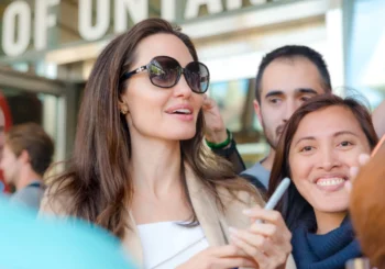 Angelina Jolie stojí mezi lidmi.
