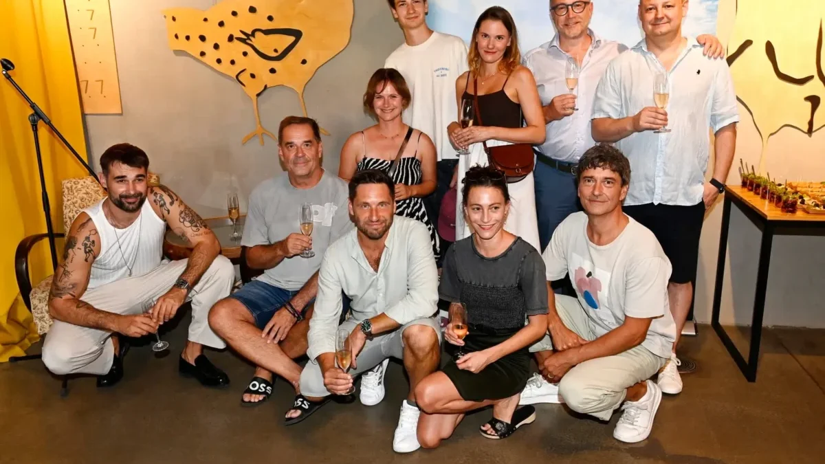 lidé u zdi pózují na fotku