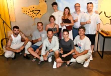 lidé u zdi pózují na fotku