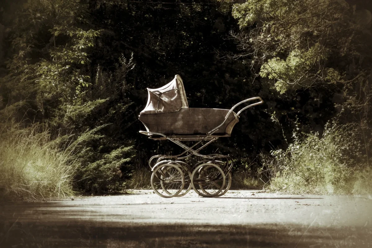 Na cestě stojí starý kočárek.