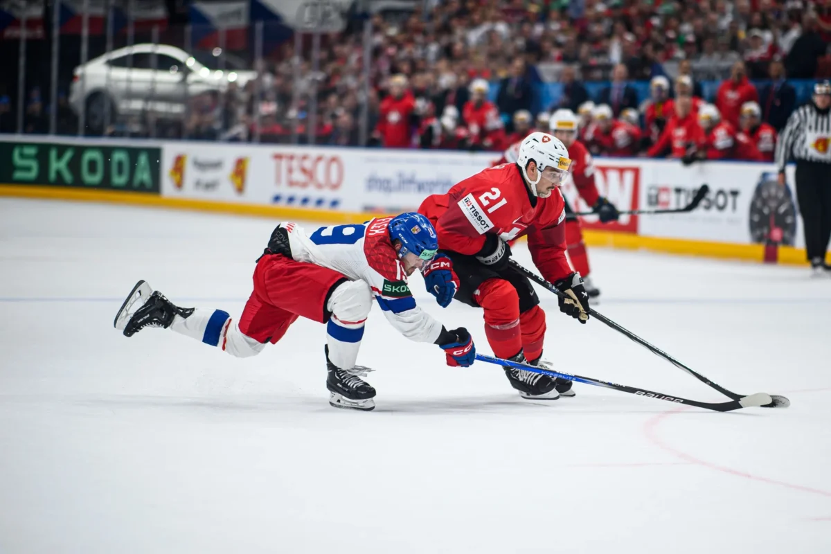 Hokejisté soupeří o puk. 