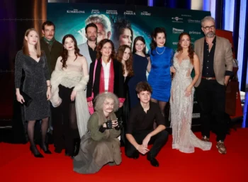 Herci stojí na červeném koberci.