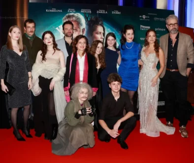 Herci stojí na červeném koberci.