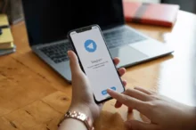 Člověk v ruce drží telefon s Telegramem.