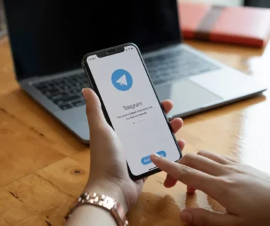 Člověk v ruce drží telefon s Telegramem.