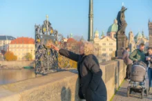 Žena sahá na část Karlova mostu.
