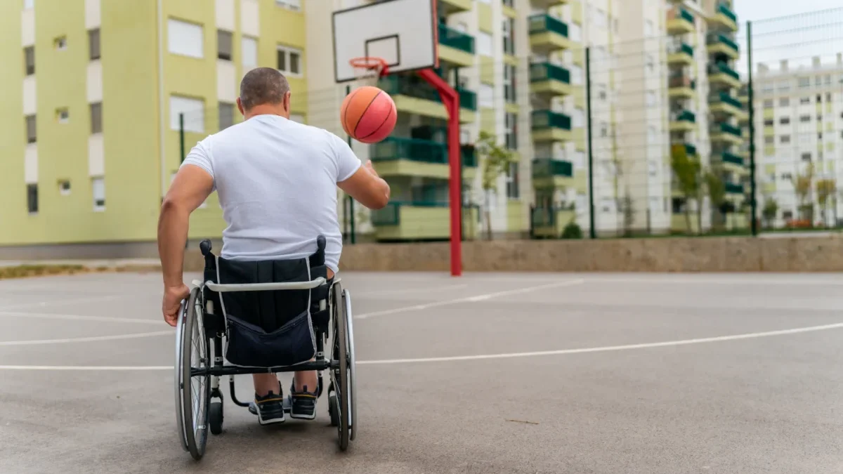 Postižený člověk v ruce drží míč.