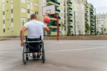 Postižený člověk v ruce drží míč.