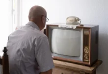 Starý muž sedí před TV.