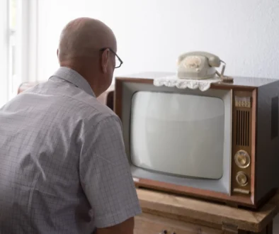 Starý muž sedí před TV.