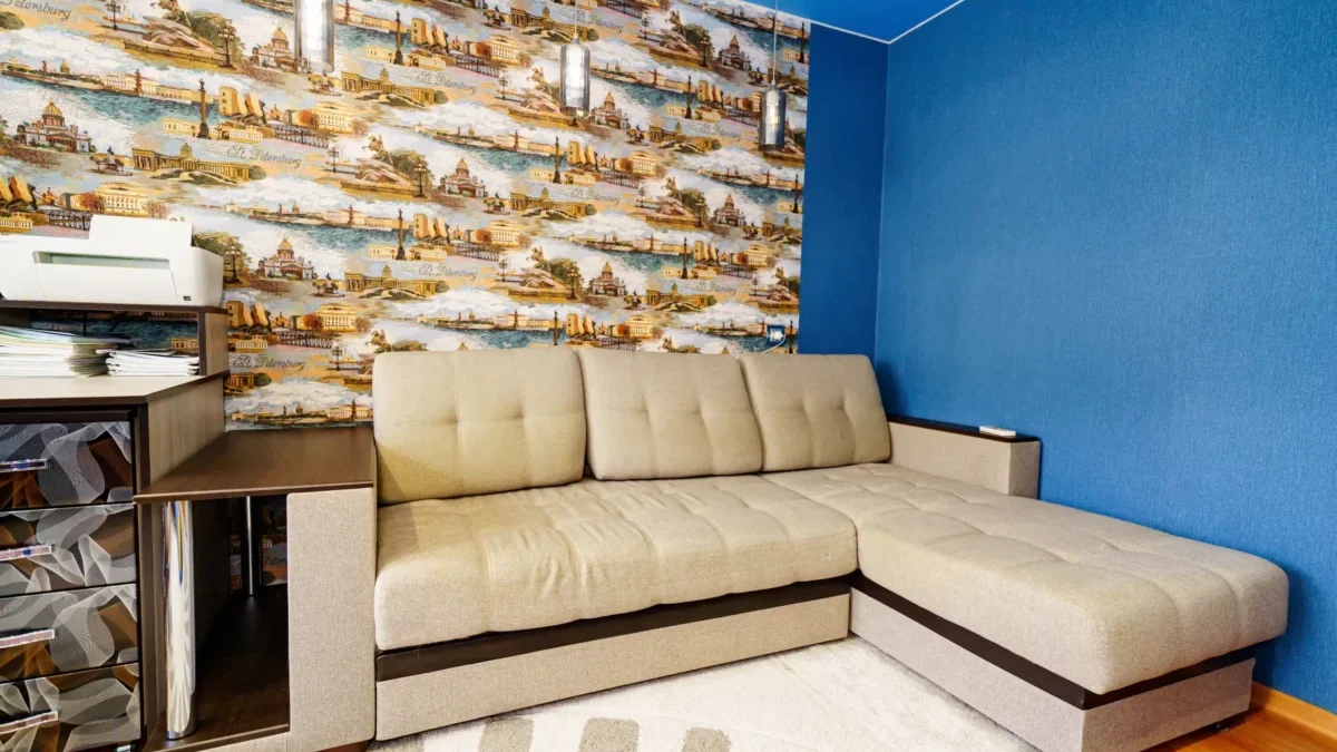 Rohový gauč stojící u zdi