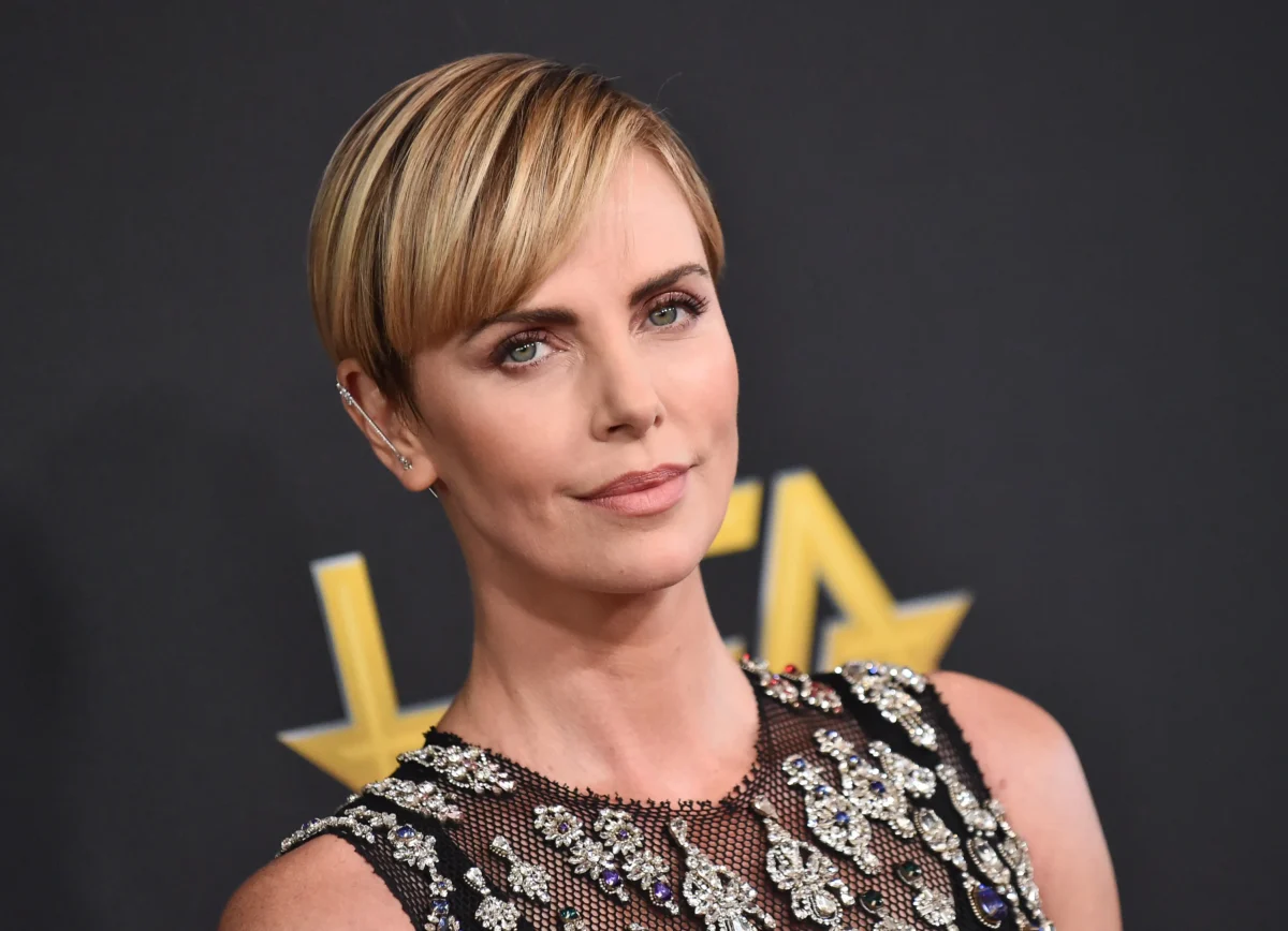 Charlize Theron se usmívá.