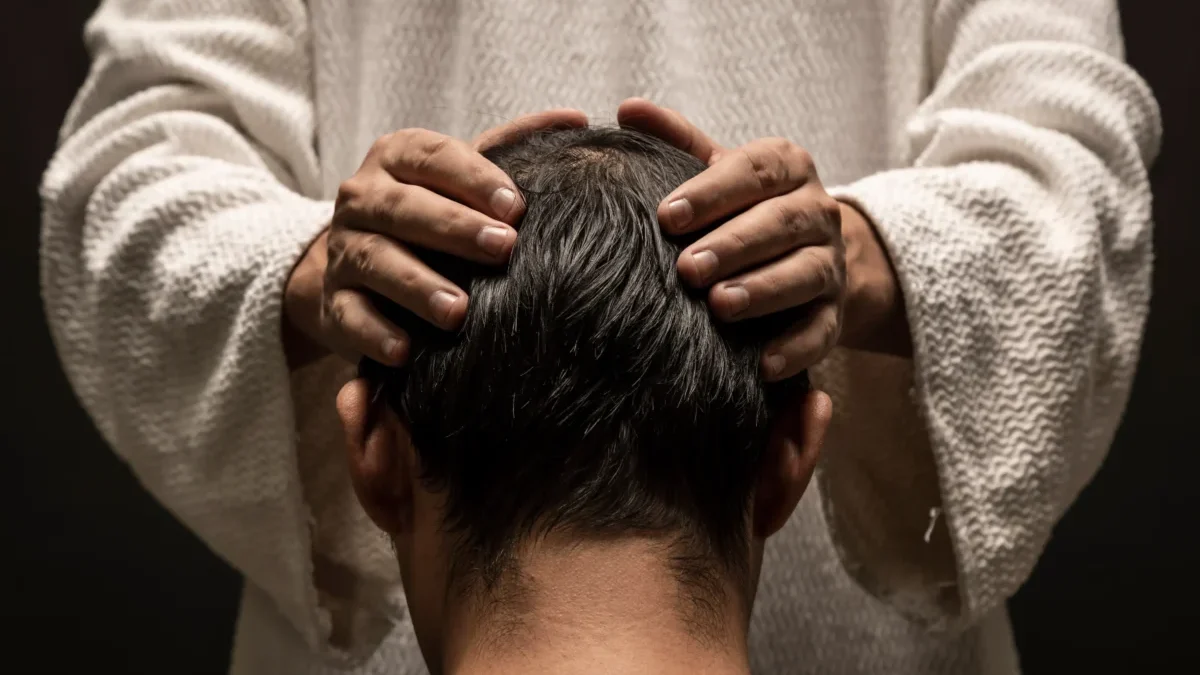 Muž drží chlapce na hlavě.