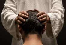 Muž drží chlapce na hlavě.