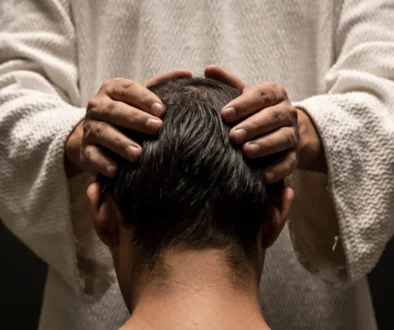 Muž drží chlapce na hlavě.