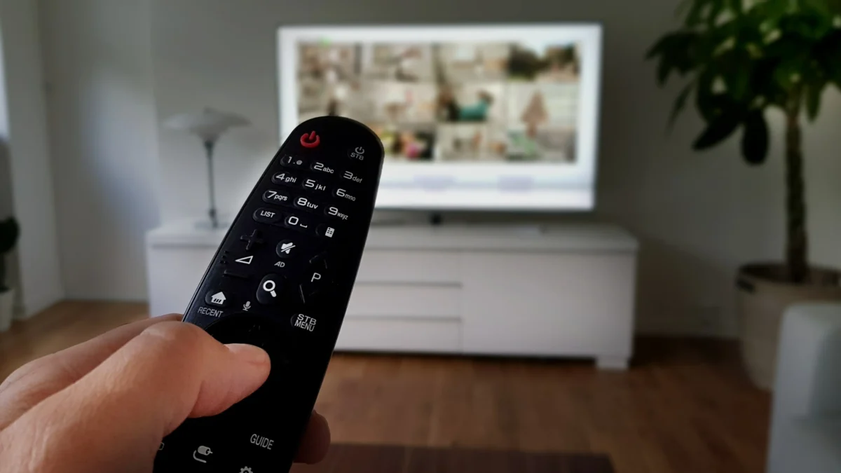 Člověk míří ovladačem na TV.