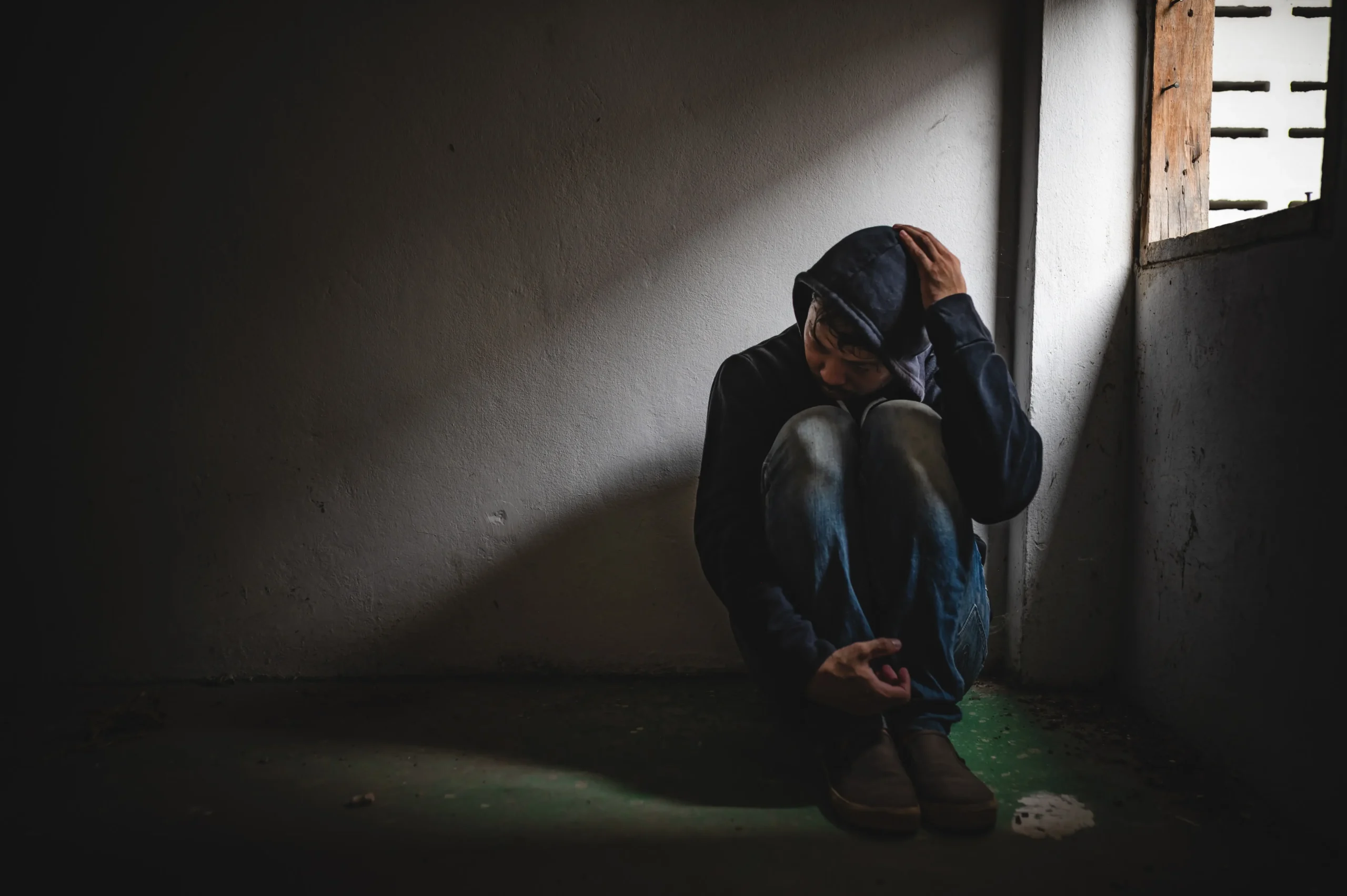 Muž sedící na chodbě 