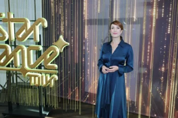 Tereza Kostková stojí vedle nápisu.