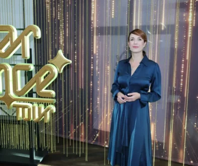 Tereza Kostková stojí vedle nápisu.