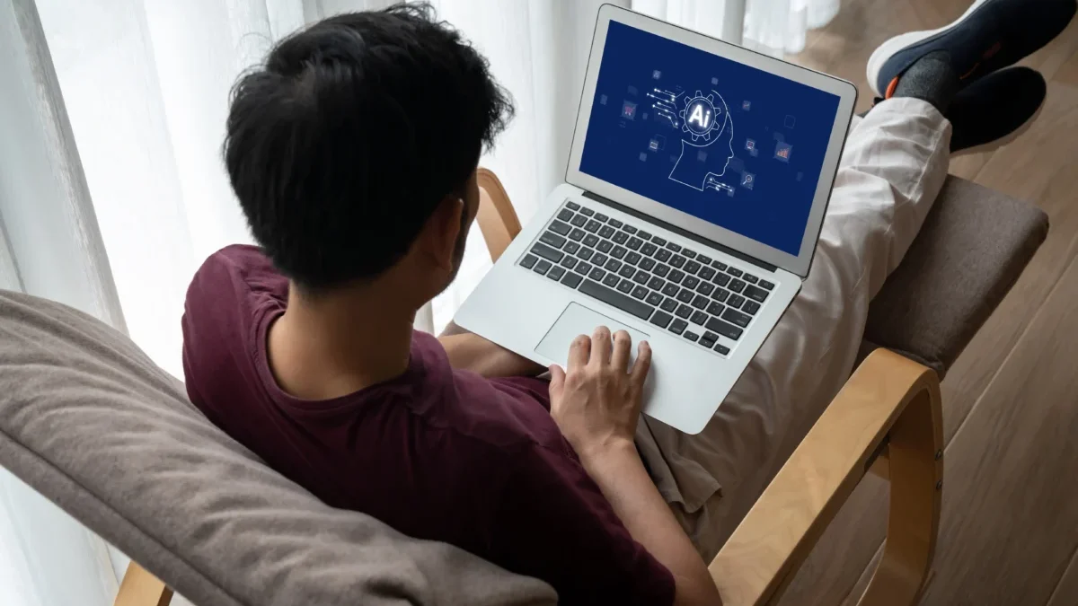 Muž má na klíně notebook s AI.