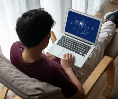 Muž má na klíně notebook s AI.