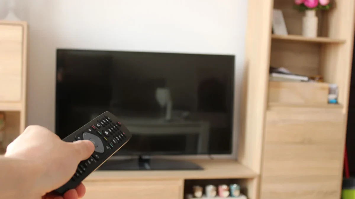 Člověk ovladačem míří na TV.