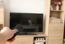 Člověk ovladačem míří na TV.