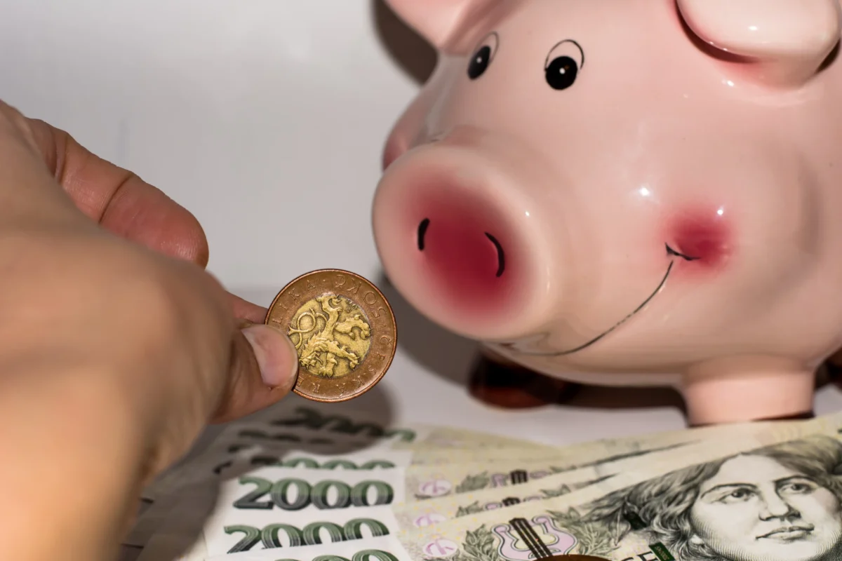 Člověk k pokladničce přikládá peníze.