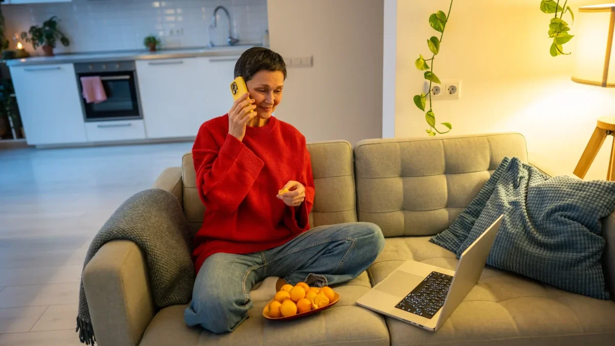 Žena telefonuje na gauči.